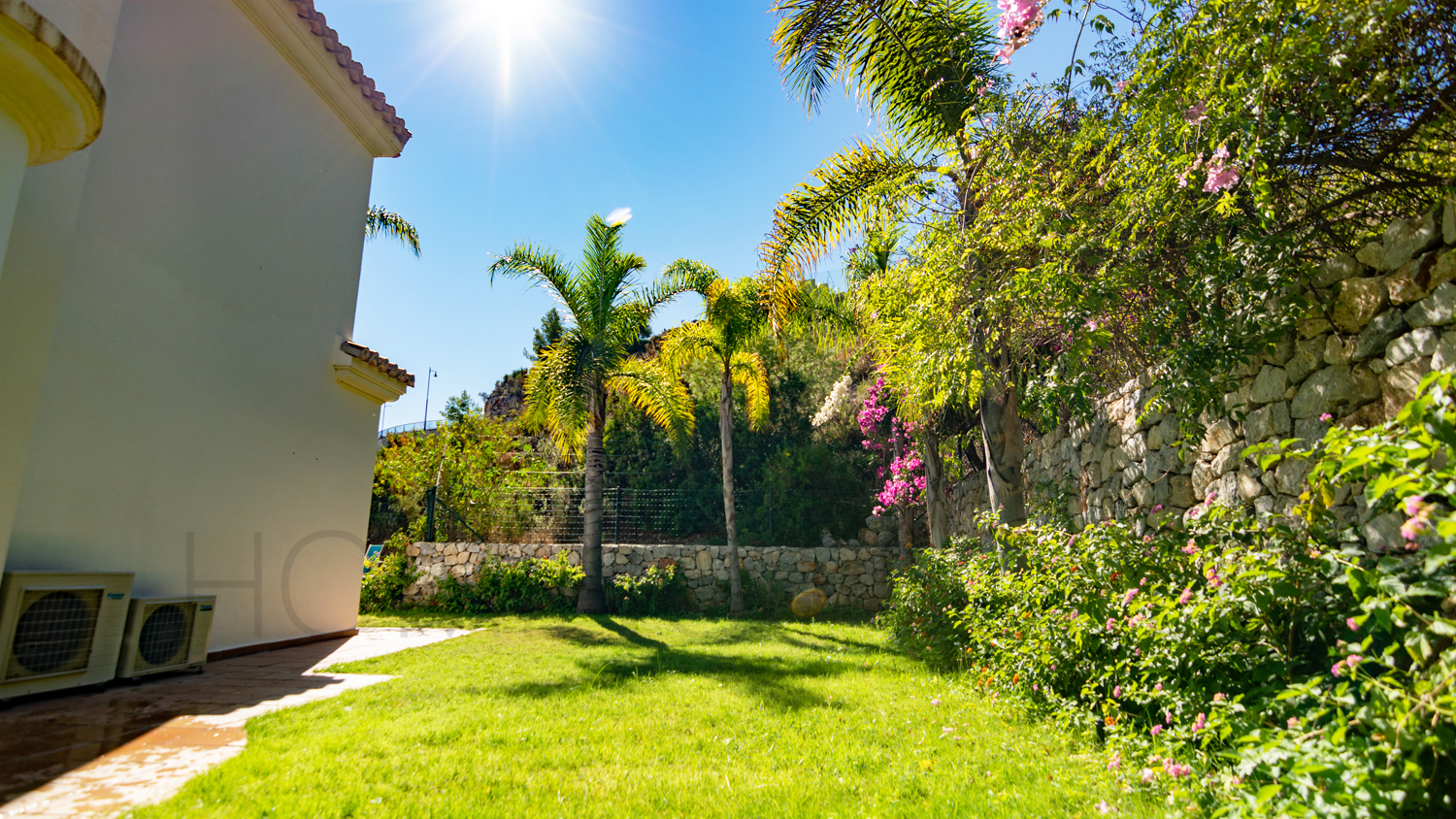 Une mignonne villa entourée de jardins avec vue latérale sur la mer