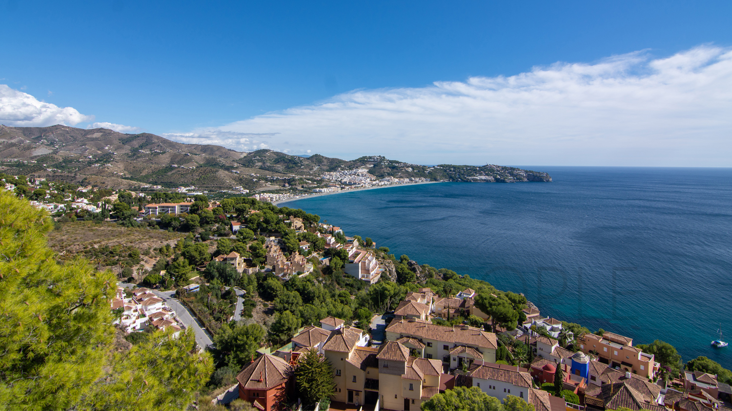 Une mignonne villa entourée de jardins avec vue latérale sur la mer