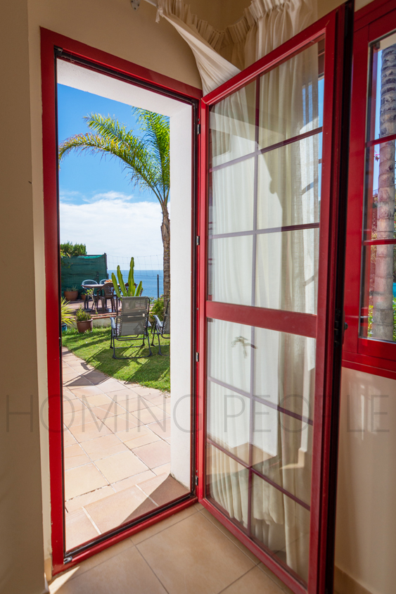 Une mignonne villa entourée de jardins avec vue latérale sur la mer