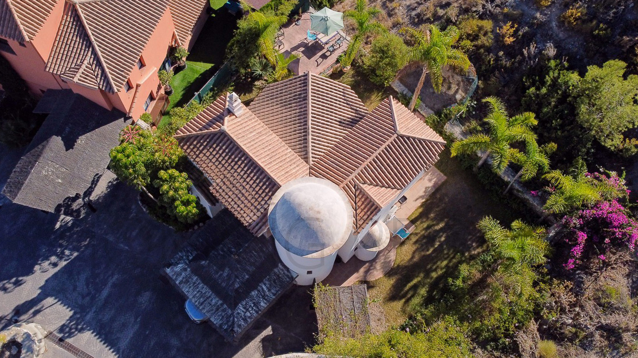Une mignonne villa entourée de jardins avec vue latérale sur la mer