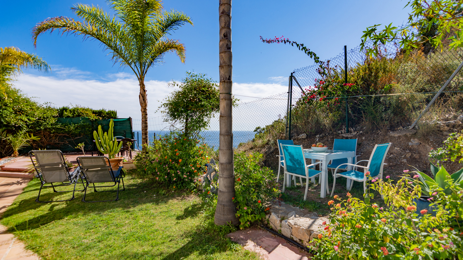 Une mignonne villa entourée de jardins avec vue latérale sur la mer