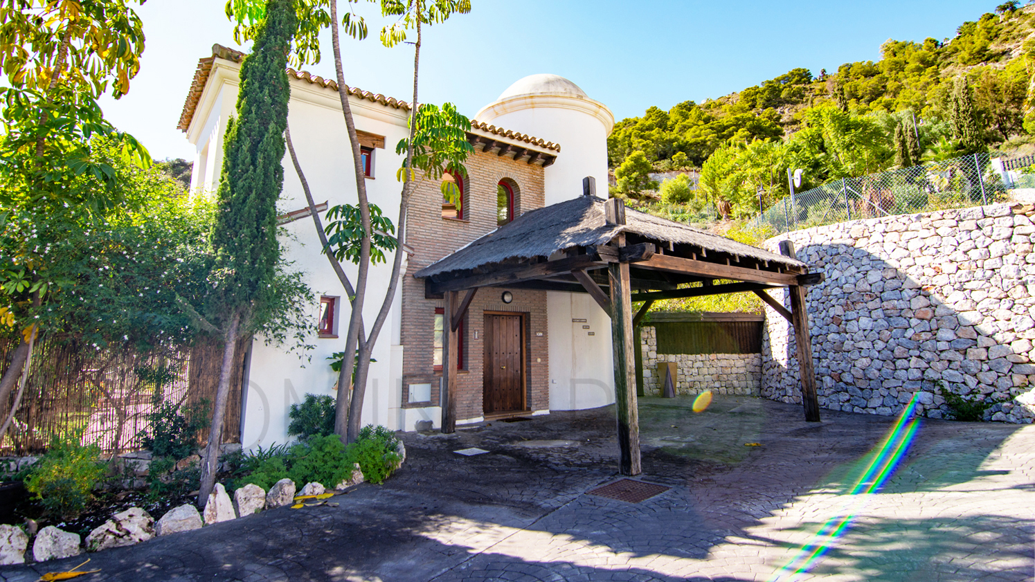 Une mignonne villa entourée de jardins avec vue latérale sur la mer