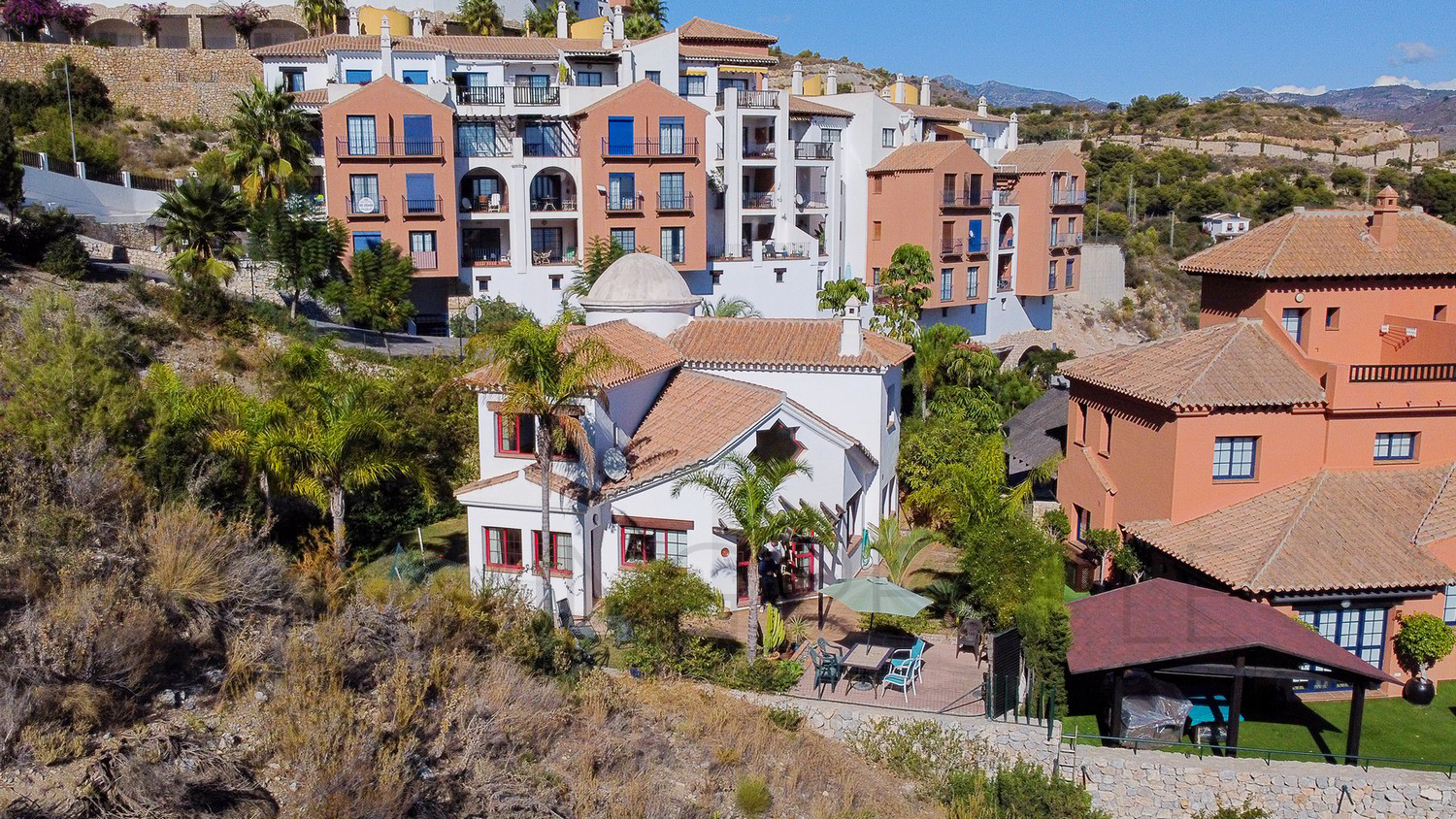 Une mignonne villa entourée de jardins avec vue latérale sur la mer
