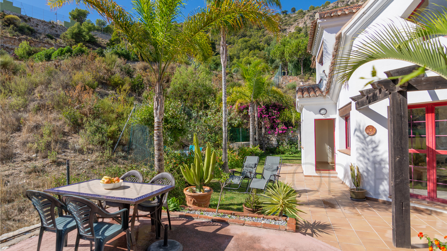 Une mignonne villa entourée de jardins avec vue latérale sur la mer