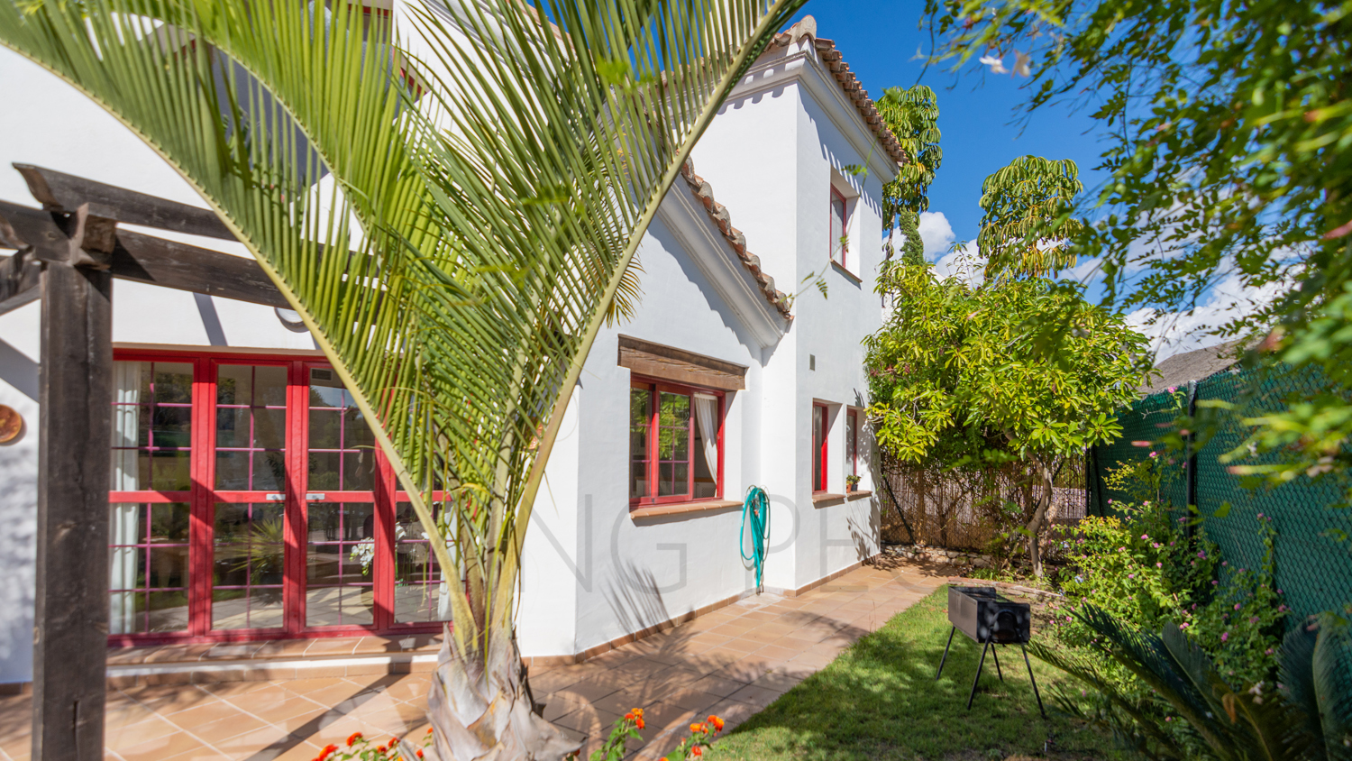 Une mignonne villa entourée de jardins avec vue latérale sur la mer