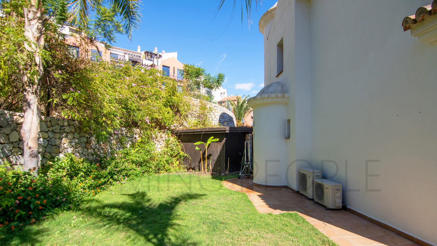Une mignonne villa entourée de jardins avec vue latérale sur la mer