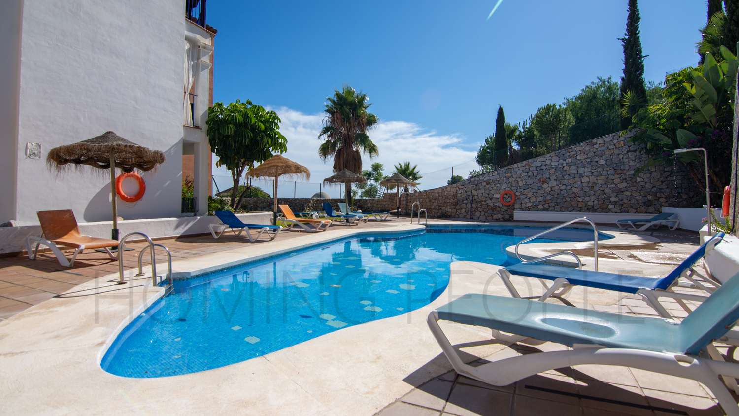 Une mignonne villa entourée de jardins avec vue latérale sur la mer